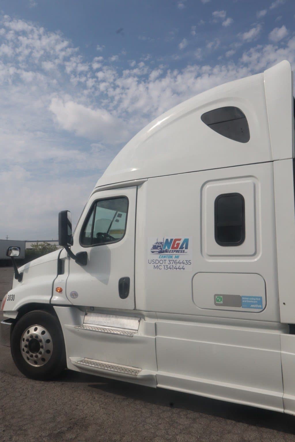 NGA Express branded tractor cab showing company markings and carrier credentials.